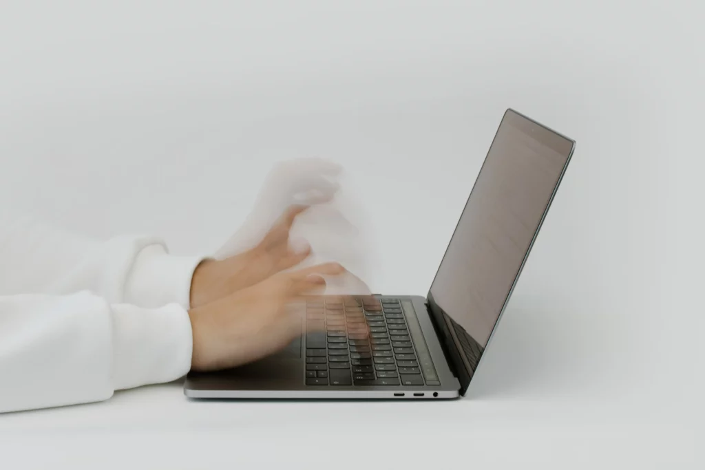 Fotografía de la estela de unas manos escribiendo de rápidamente el en teclado de un portátil. Extraída de pexels, para añadir a la parte de creación de contenido textual de Niri Rodríguez Fotógrafa y social media.